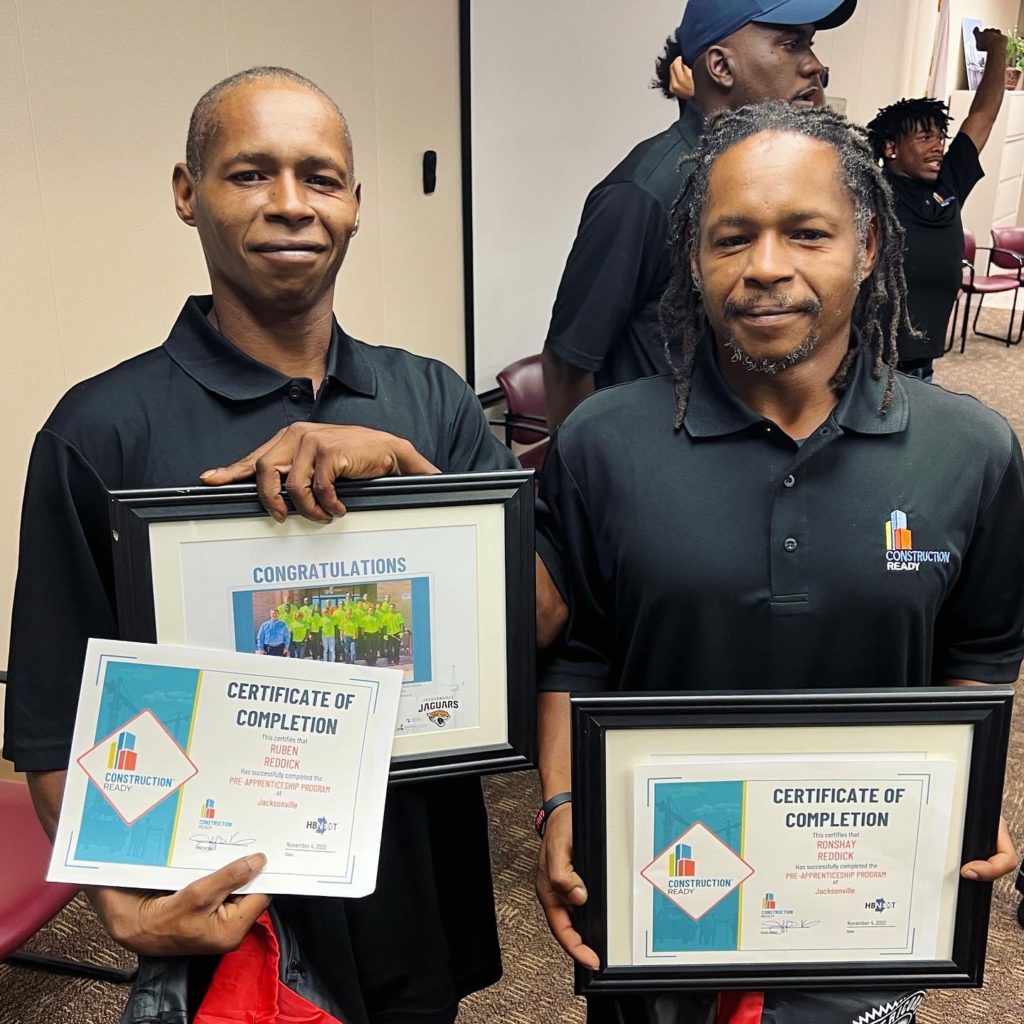 Twin brothers, Ronshay and Ruben Reddick, at Construction Ready class four graduation holding their completion certificates
